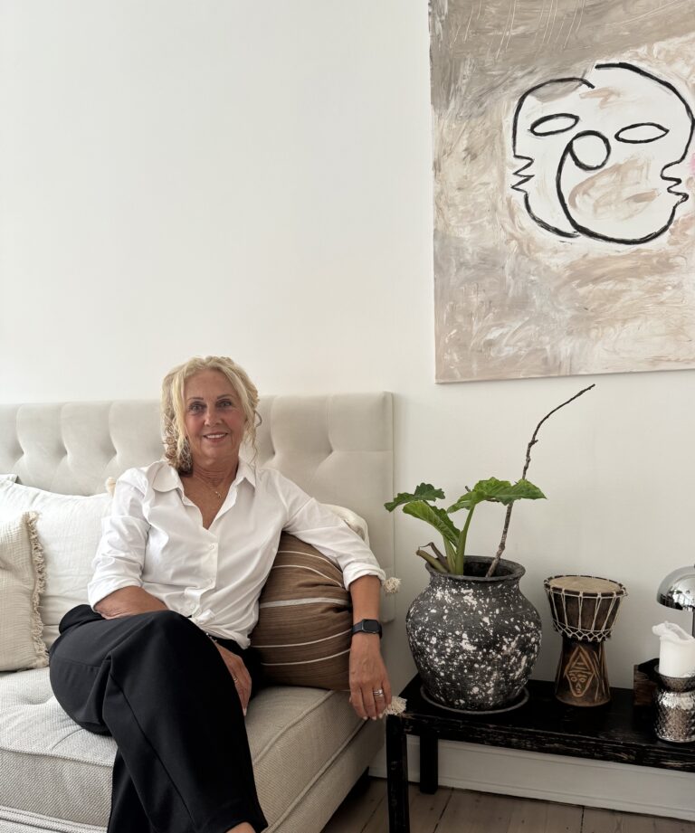 Charlotte sidder på sofa til billede